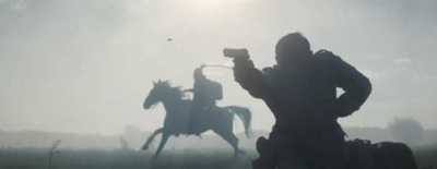 a silhouette of a man on a horse with a gun