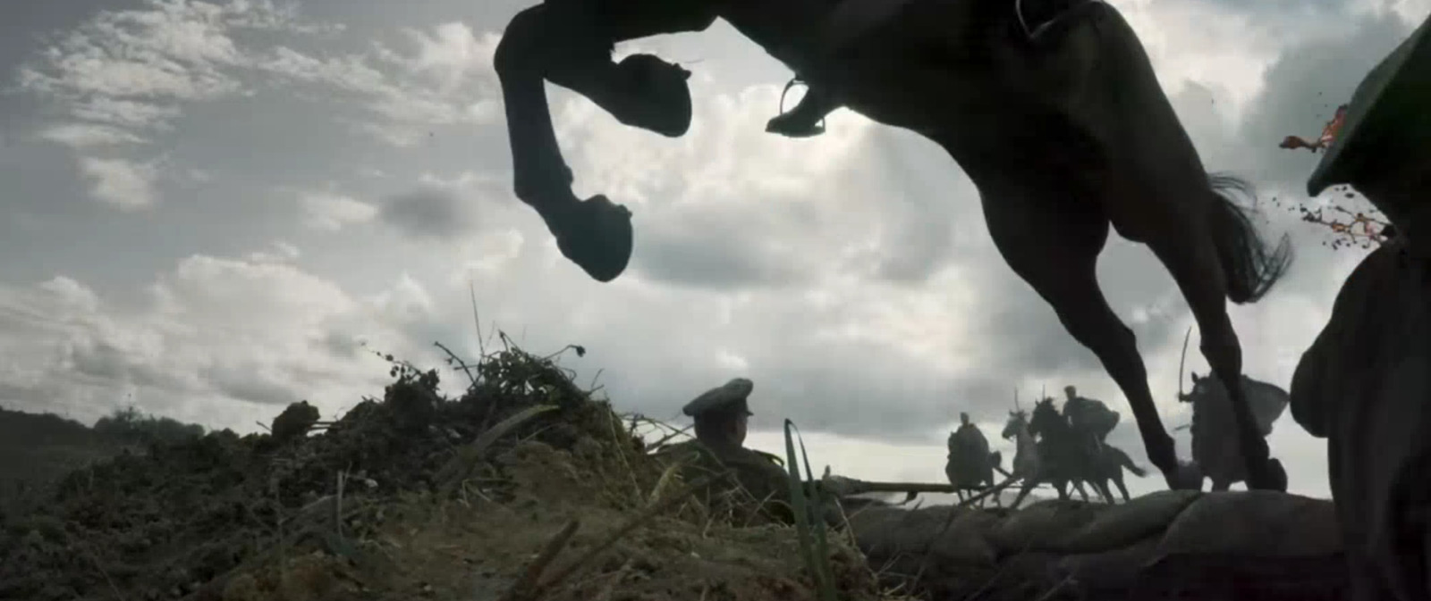 a man riding a horse over a pile of hay