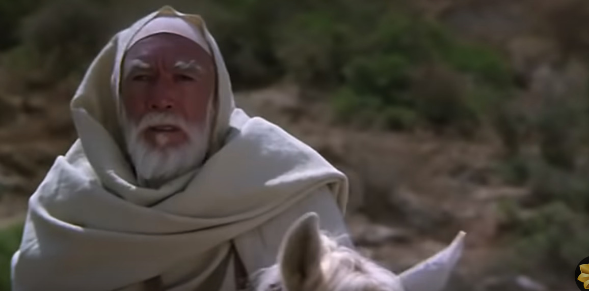 a man in a white robe riding a white horse