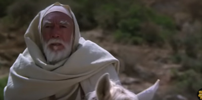 a man in a white robe riding a white horse