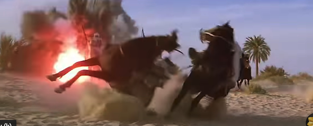 a group of men riding horses through a desert