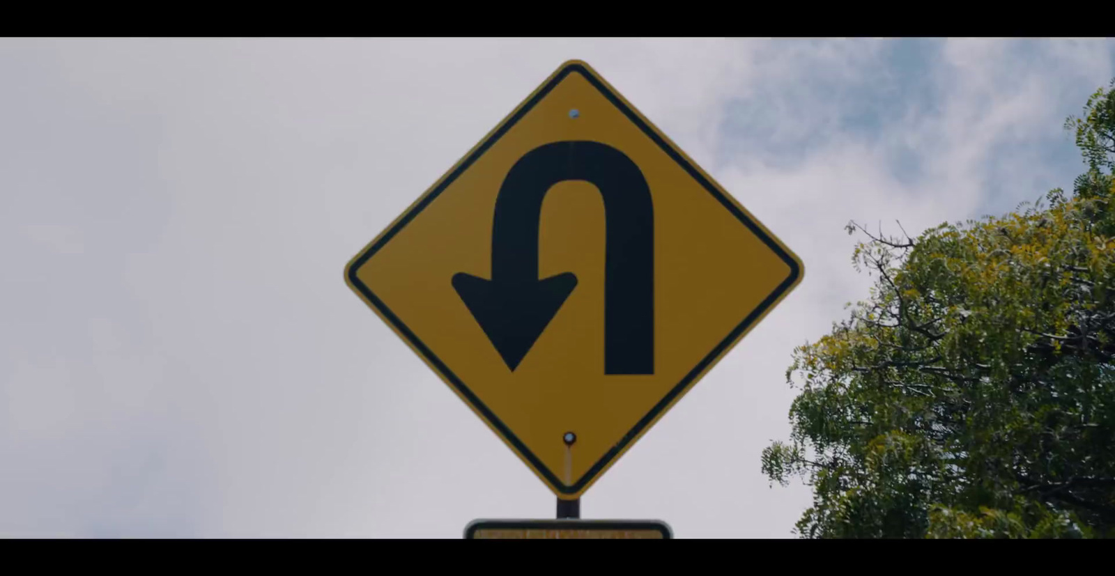 a close up of a street sign with trees in the background