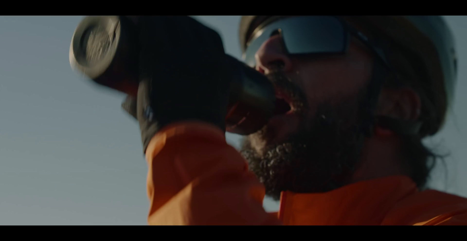 a man with a beard and sunglasses holding a microphone