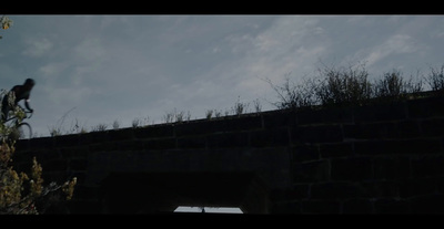 a man riding a bike over a bridge