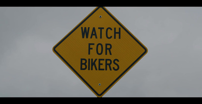 a yellow sign that says watch for bikers