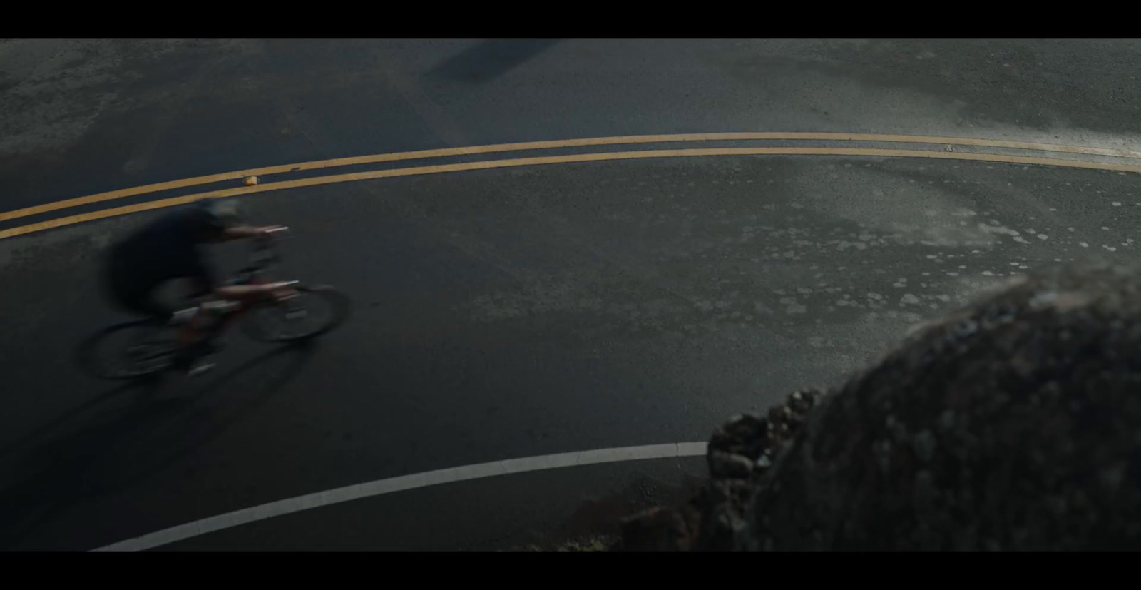 a man riding a bike down a curvy road