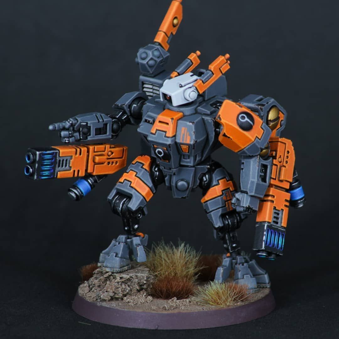 an orange and black robot with a gun