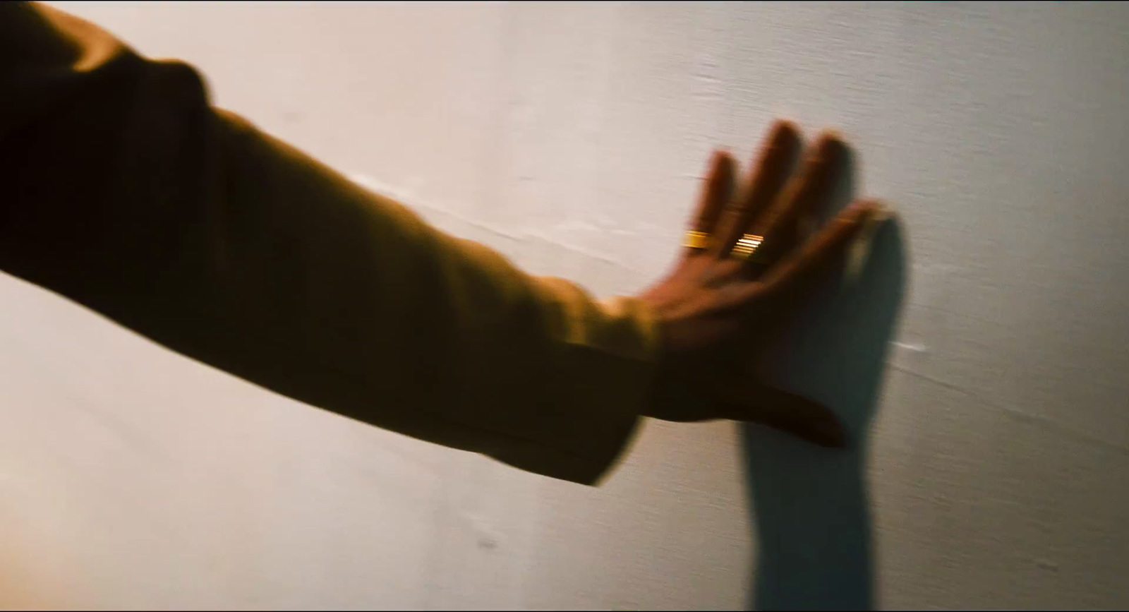 a person's hand reaching for something on a wall