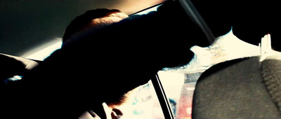 a man driving a car while holding a cell phone