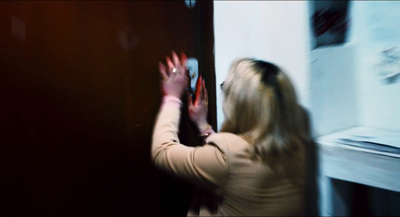 a woman standing in front of a black door