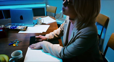 a woman sitting at a table using a laptop computer