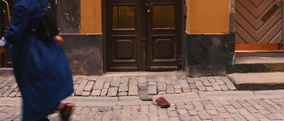 a woman in a blue dress is walking down the street