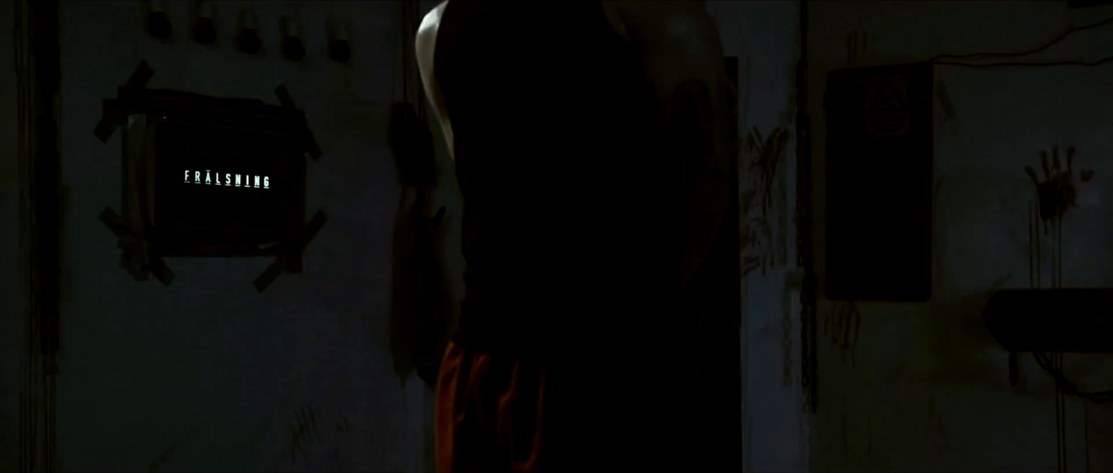 a man standing in a dark room with his back to the camera