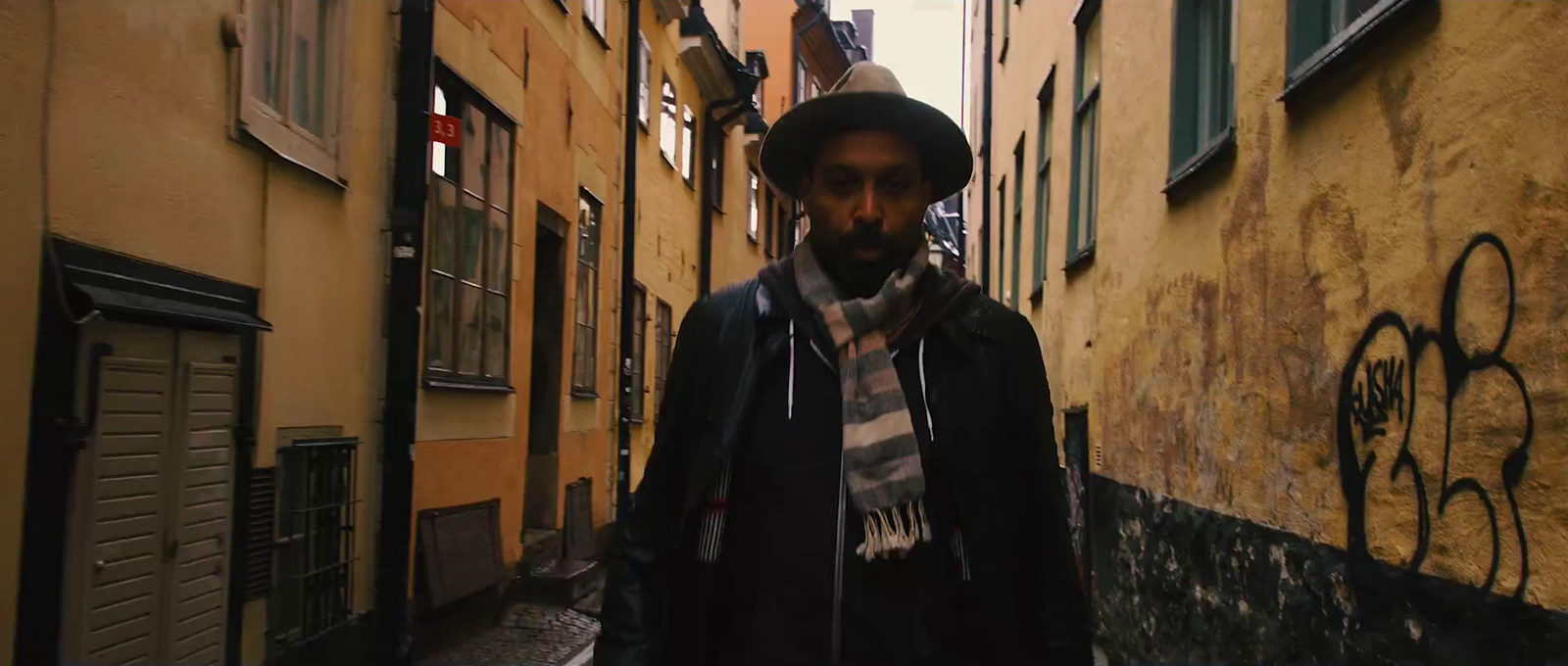 a man walking down a narrow alley way