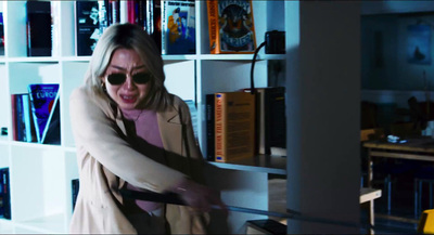 a woman in a room with a book shelf full of books