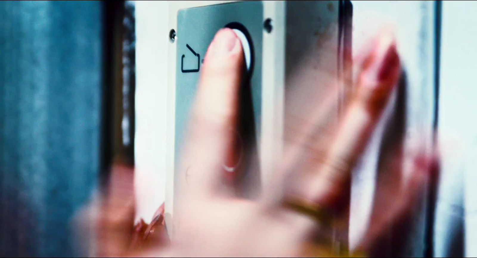 a hand is pressing a button on a door