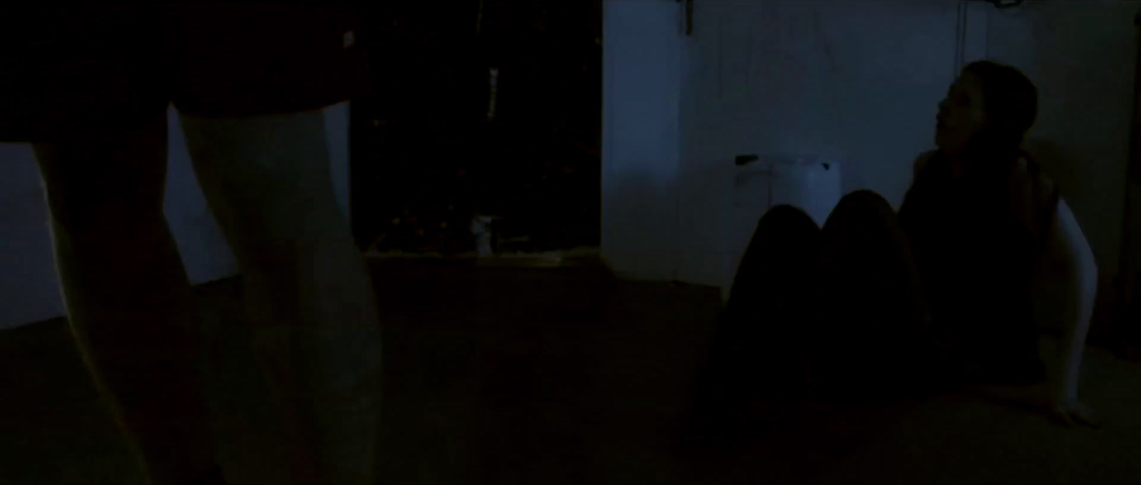 a person sitting on the floor in a dark room