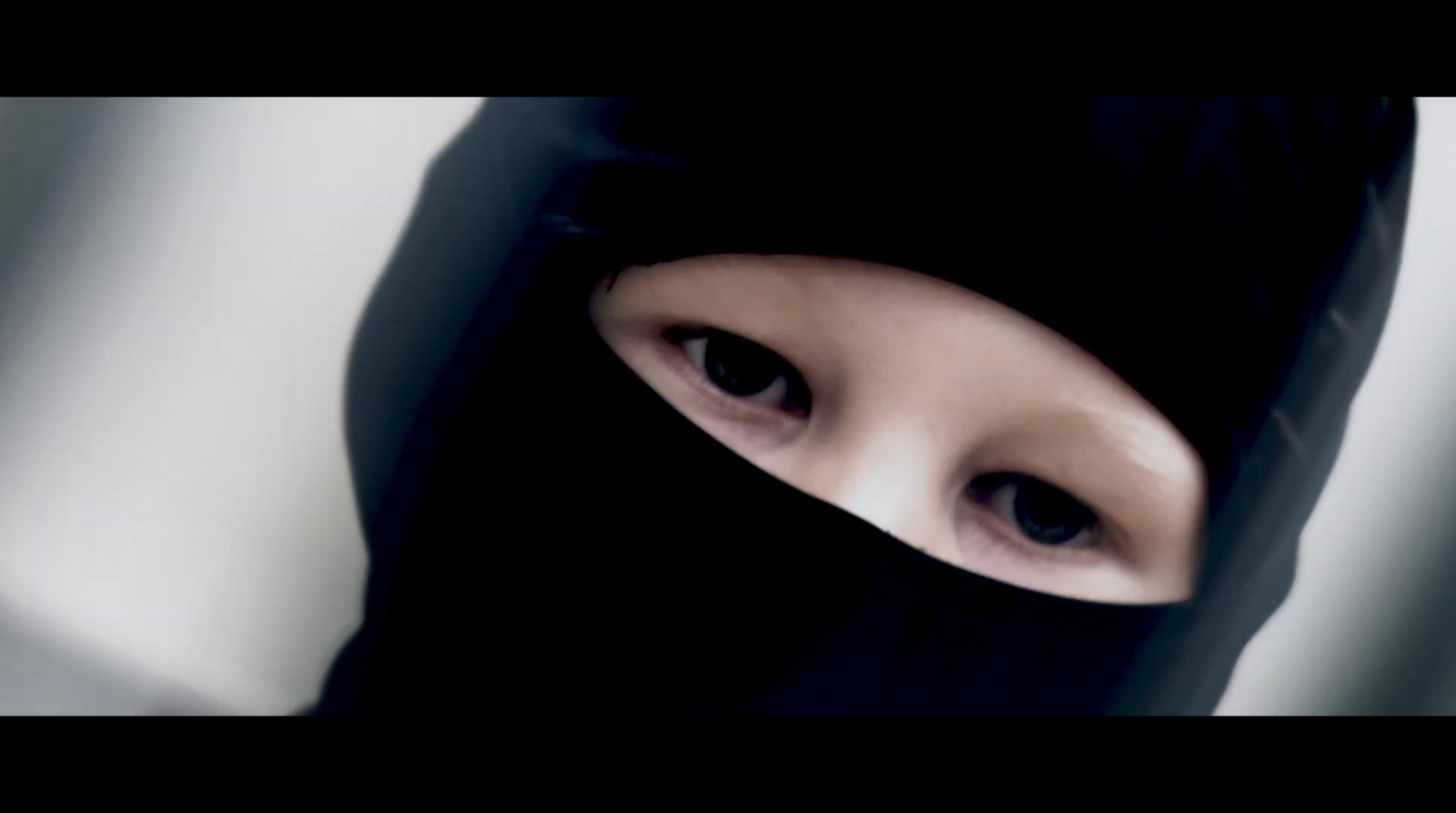 a woman wearing a black veil and looking into the camera