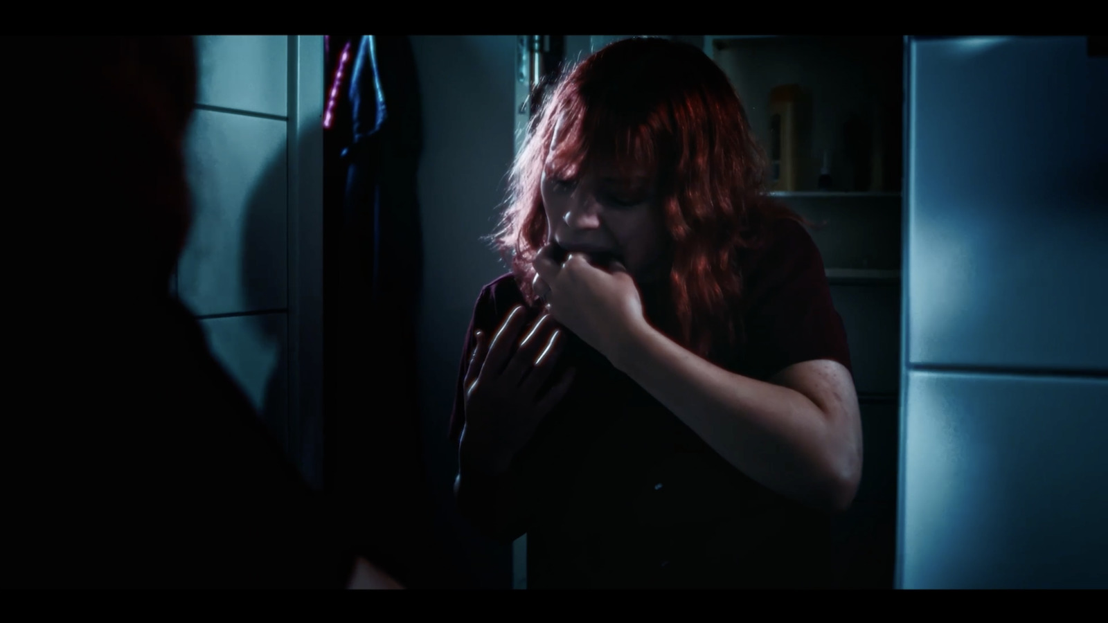 a woman with red hair standing in a kitchen