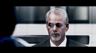 a man in a suit and tie sitting in front of a mirror