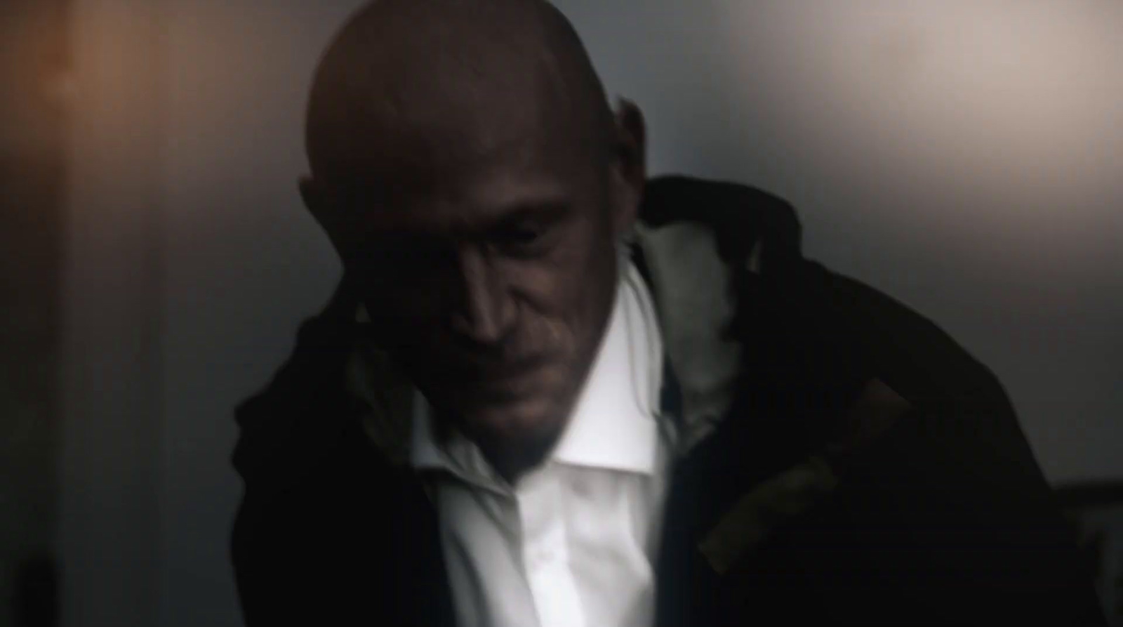 a bald man in a white shirt and black jacket