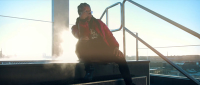 a man in a red jacket is sitting on a ledge