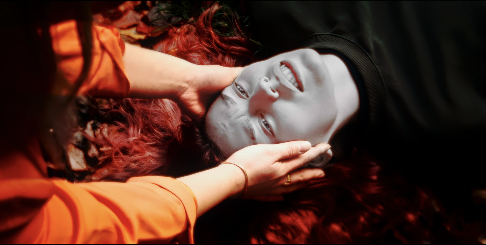 a woman with red hair and a white mask