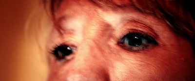 a close up of a woman's face with a toothbrush in her mouth