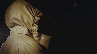 a person wearing a hooded jacket in the dark