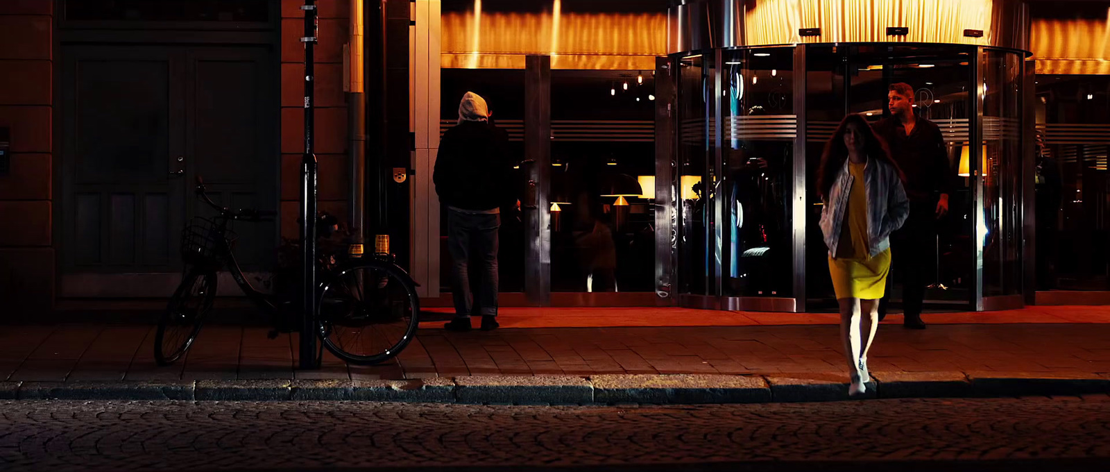 a woman standing in front of a building at night