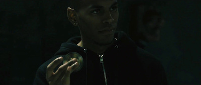 a man in a black hoodie holding a green object