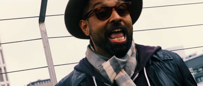 a man with a hat and sunglasses making a funny face