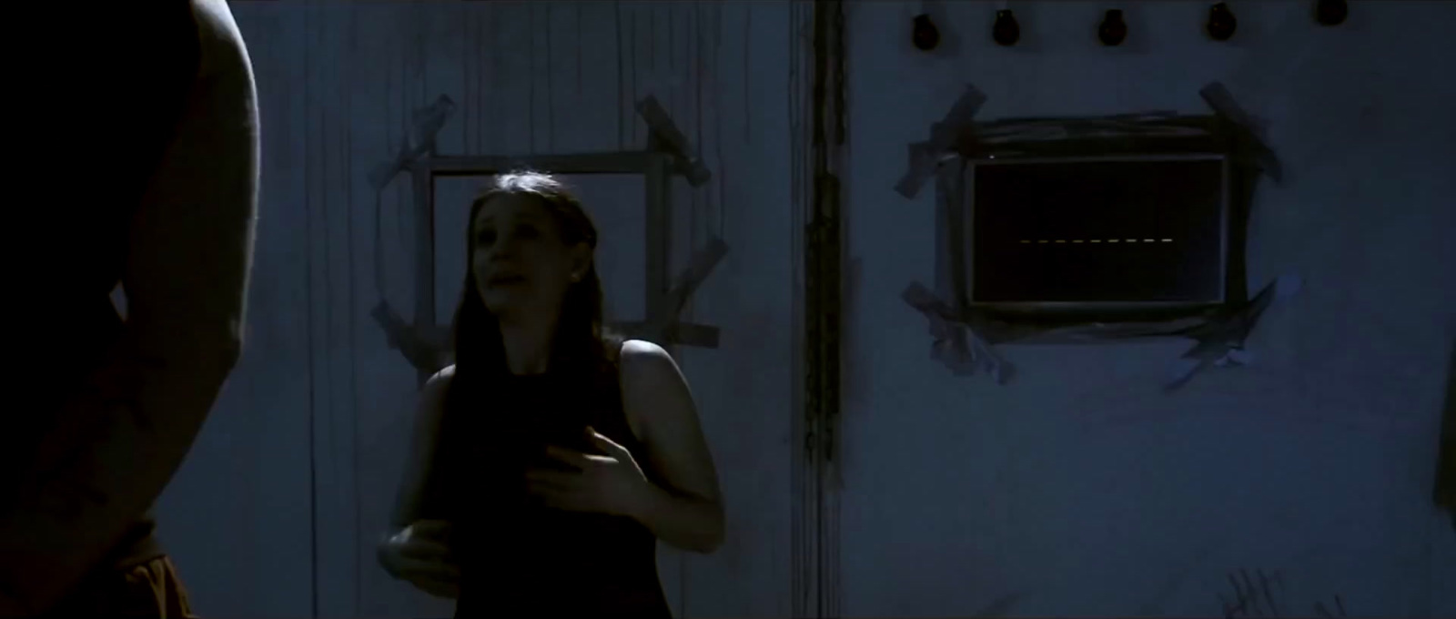 a woman standing in front of a door in a dark room