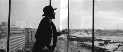 a man standing in front of a window looking out at a city