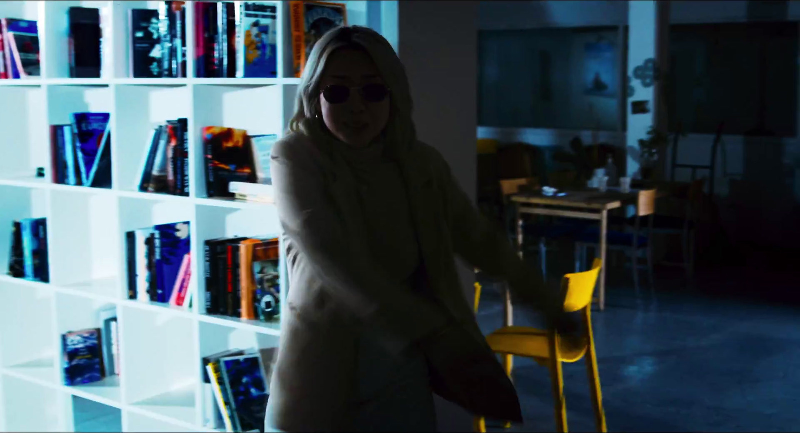 a woman standing in front of a book shelf