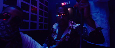 a man wearing sunglasses and a bandana in a dark room