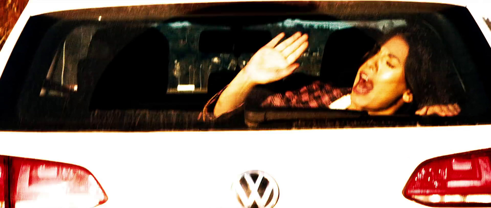 a woman is sitting in a car and waving