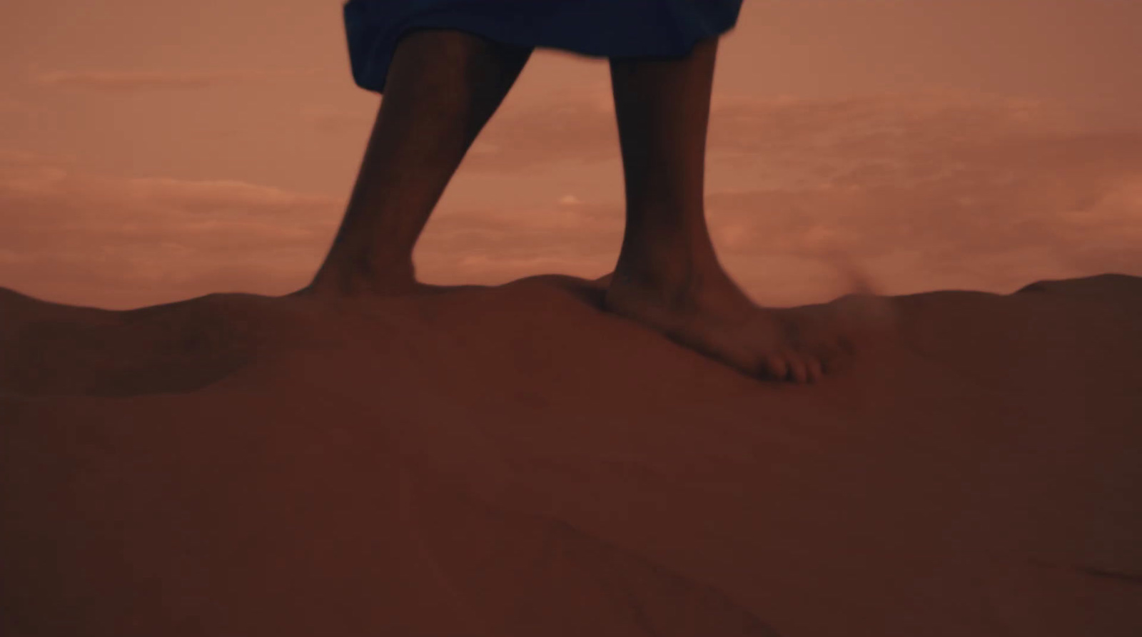 a person standing on top of a sand dune