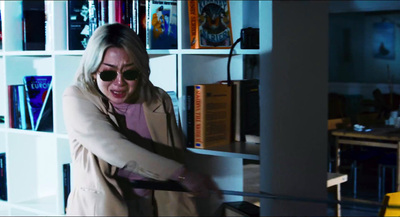 a woman in a room with a book shelf full of books