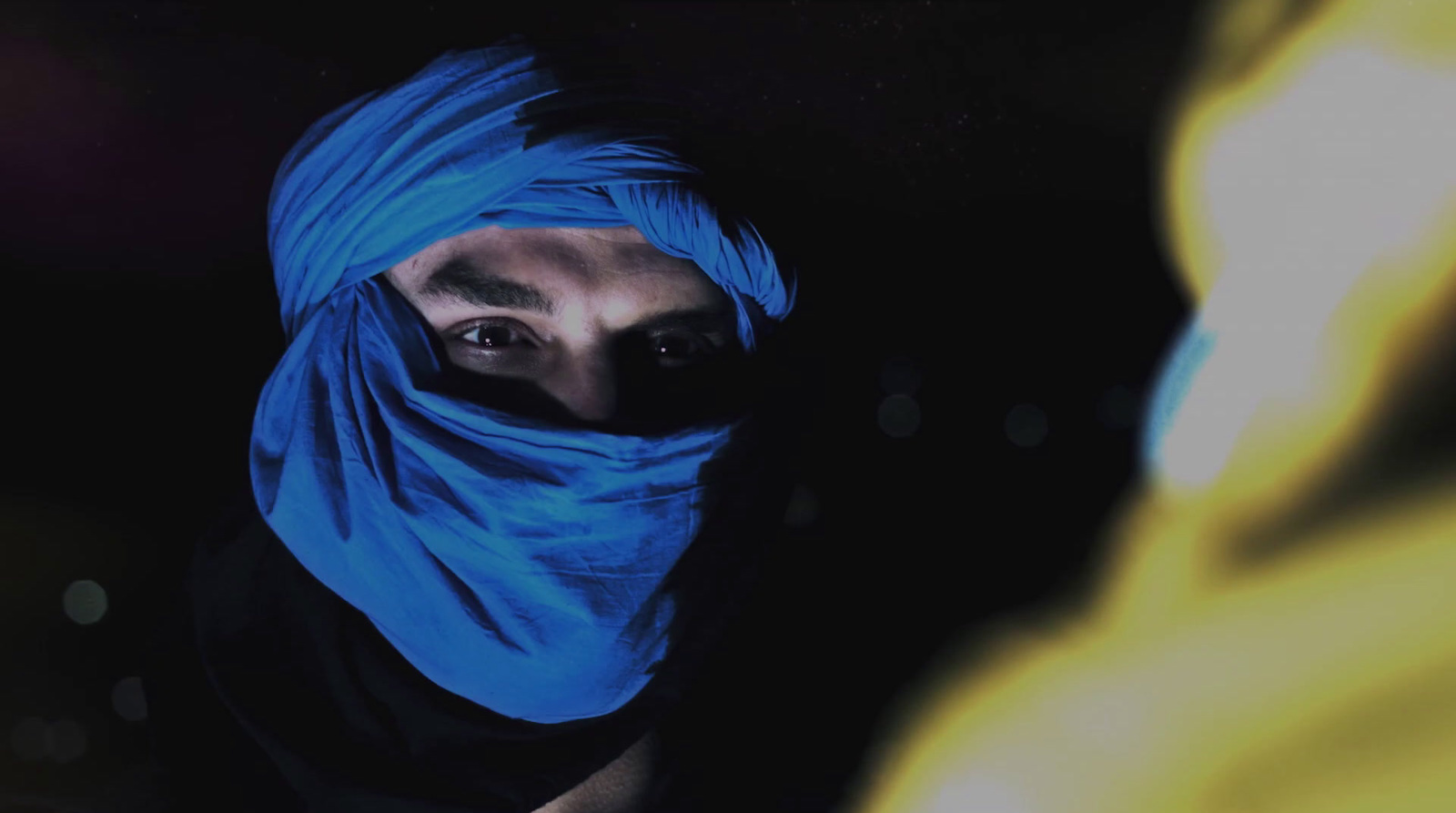 a man wearing a blue head covering over his face