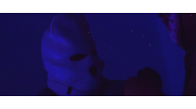 a person wearing a white mask in a dark room