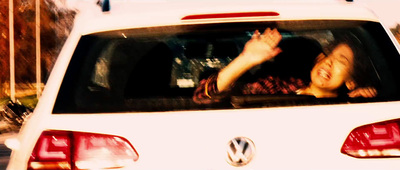 a woman sitting in the back of a white car