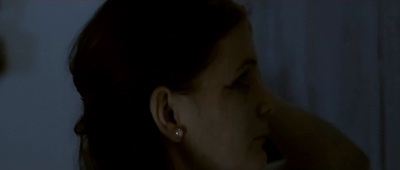 a woman with ear piercings in a dark room