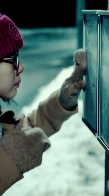 a woman in a red hat is writing on a metal box