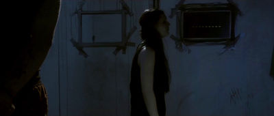 a woman standing in front of a door in a dark room