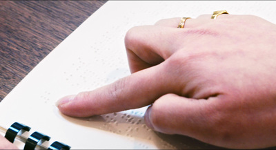 a person's finger pointing at a piece of paper