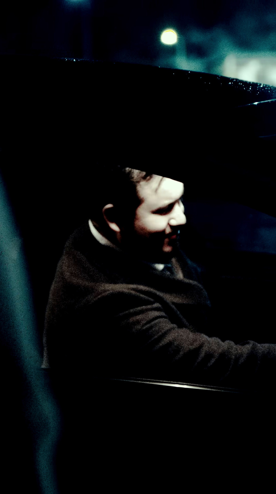 a man driving a car at night in the dark