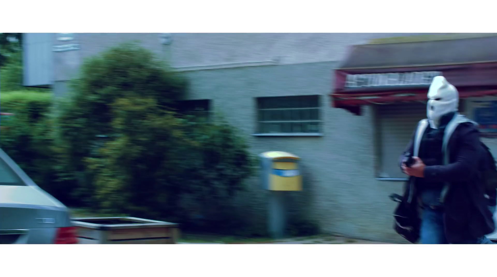 a person in a white mask walking down a street