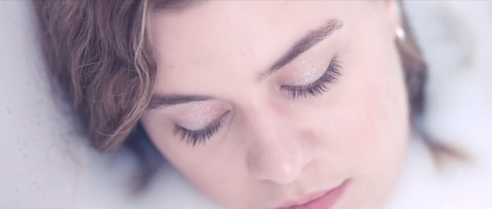 a close up of a woman with her eyes closed