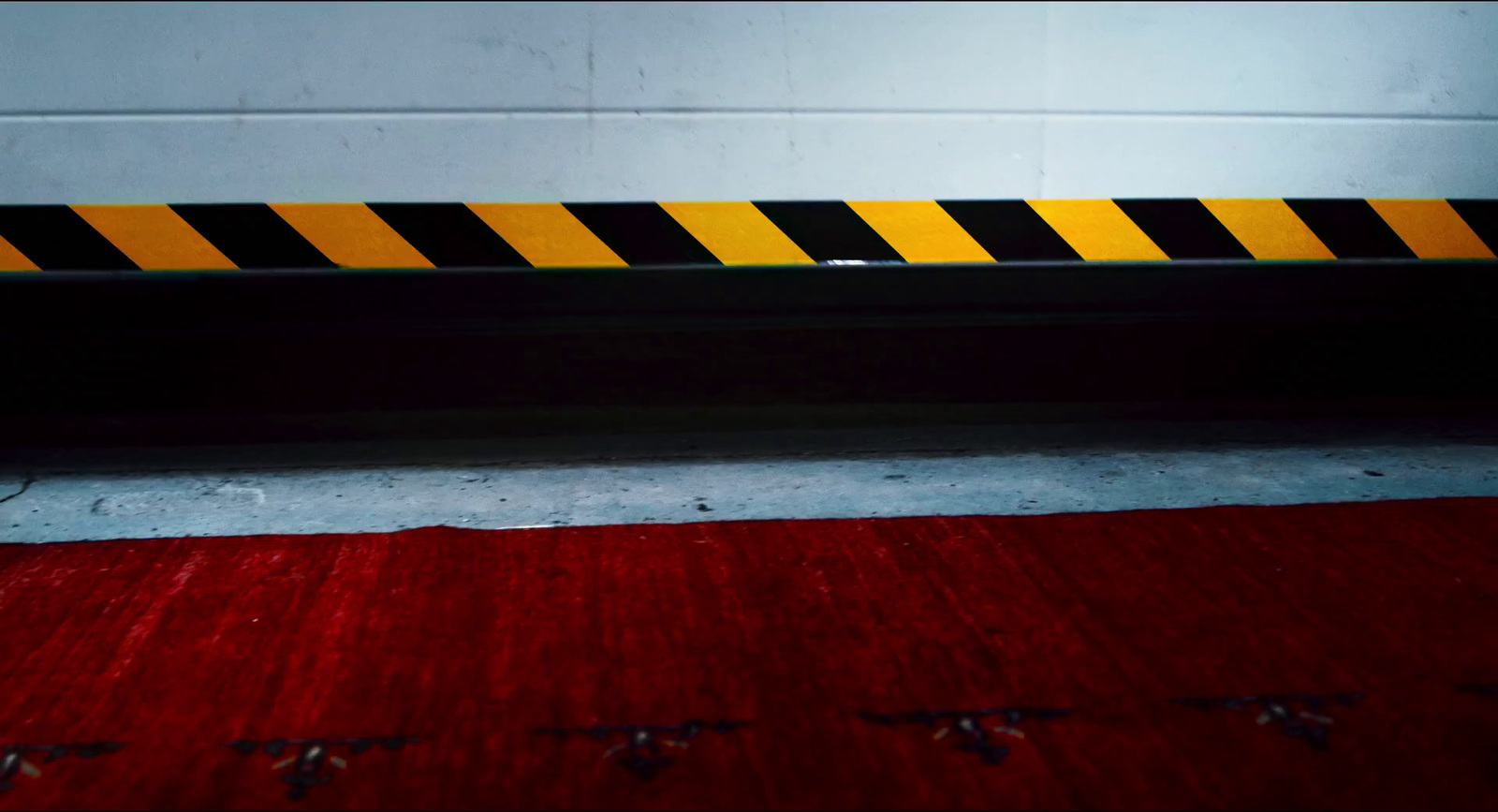 a red rug with a yellow and black stripe on it